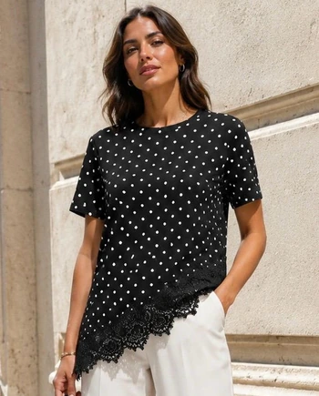 Camiseta negra de lunares blancos Virginia Cantero, de manga corta y con encaje en el bajo.