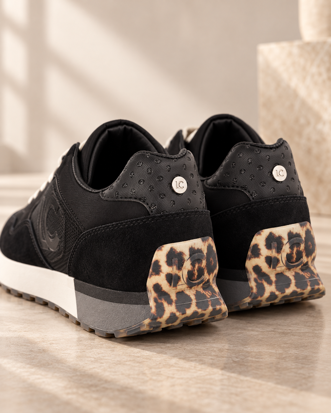Deportivas Lola Casademunt negras - detalle trasero animal print Vista trasera de las deportivas Lola Casademunt negras con detalle animal print en los talones