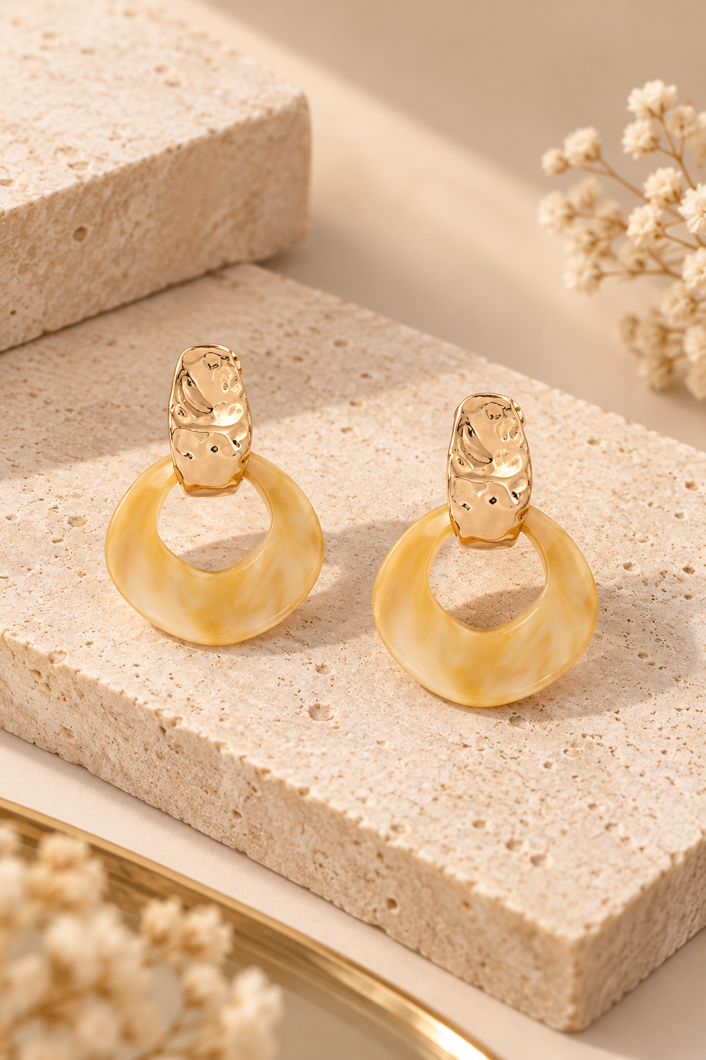 Pendientes Lola Casademunt de resina marmolada metal crudo – vista frontal Pendientes Lola Casademunt de resina marmolada en tonos beige y dorados, con pieza superior metálica texturizada y colgante de aro irregular.