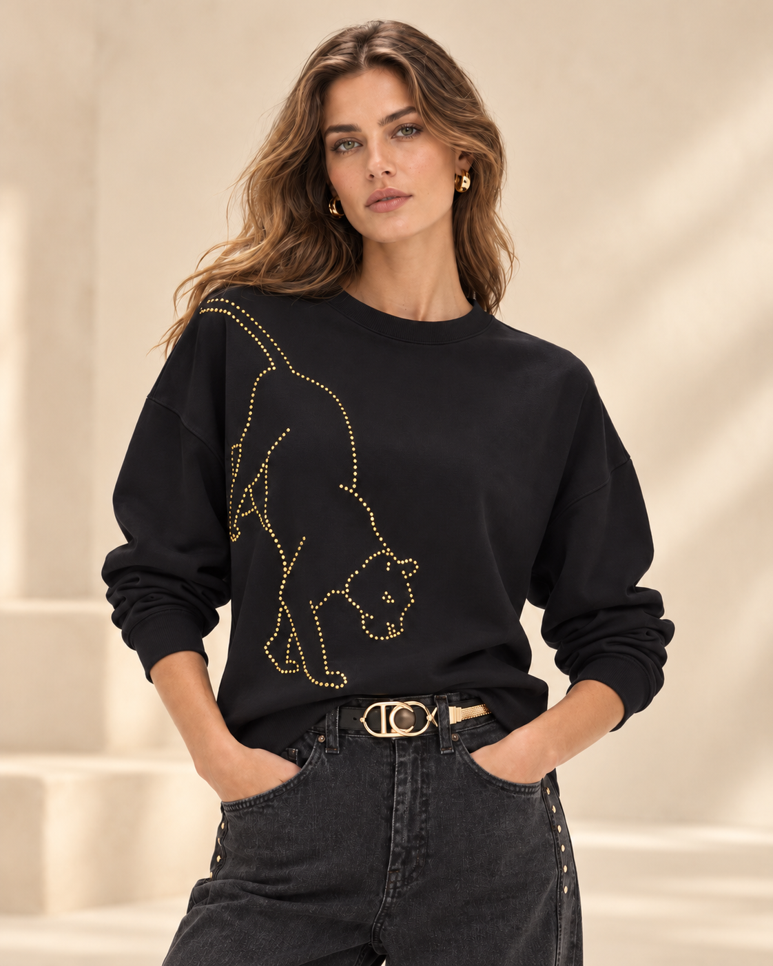 Sudadera Lola Casademunt negra leopardo cristales dorados – frontal Modelo con sudadera Lola Casademunt negra de cuello redondo y manga larga, decorada con un leopardo de cristales dorados en el delantero.