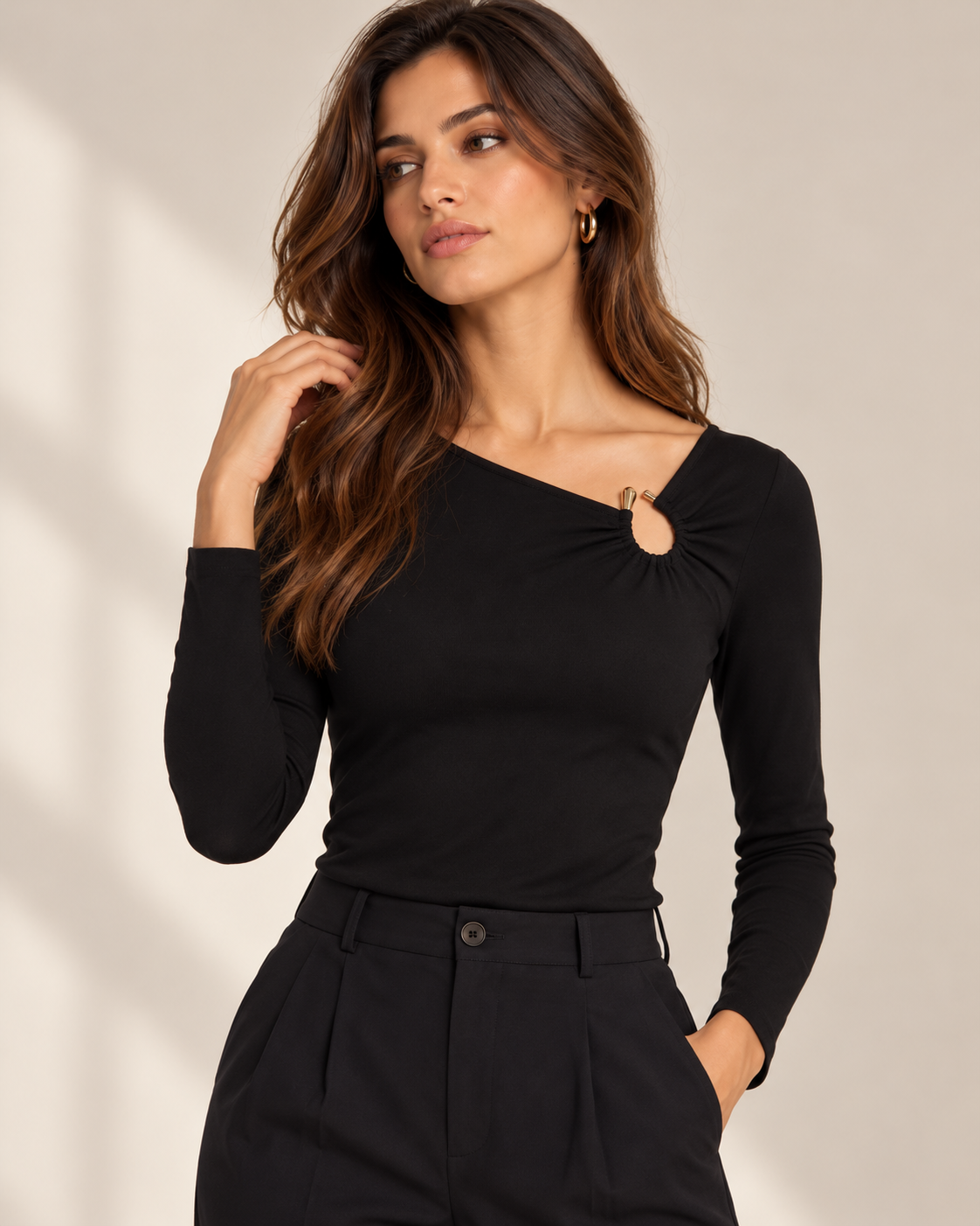 Camiseta Morgan TLADIES negra con anilla – vista frontal Modelo con camiseta Morgan TLADIES negra de manga larga, corte entallado y escote asimétrico con fruncido y anilla dorada.