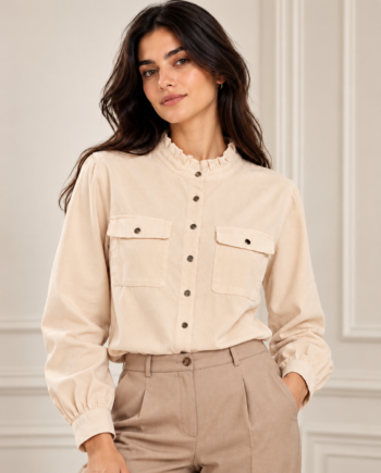 Modelo con camisa Morgan Corlac beige de pana, cuello con volante, botones delanteros y bolsillos con solapa, combinada con pantalones de vestir en tono topo.