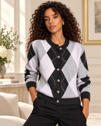 Modelo con cárdigan Morgan Mdiamo jacquard de rombos grises, blancos y negros, cuello redondo, botones joya y detalles de strass, combinado con pantalones negros.