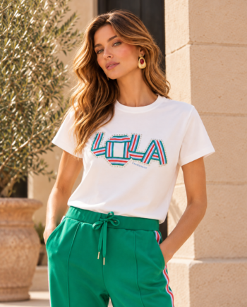 Modelo con camiseta Lola Casademunt blanca de manga corta, cuello redondo y logotipo multicolor con detalles de cristales en el frontal.