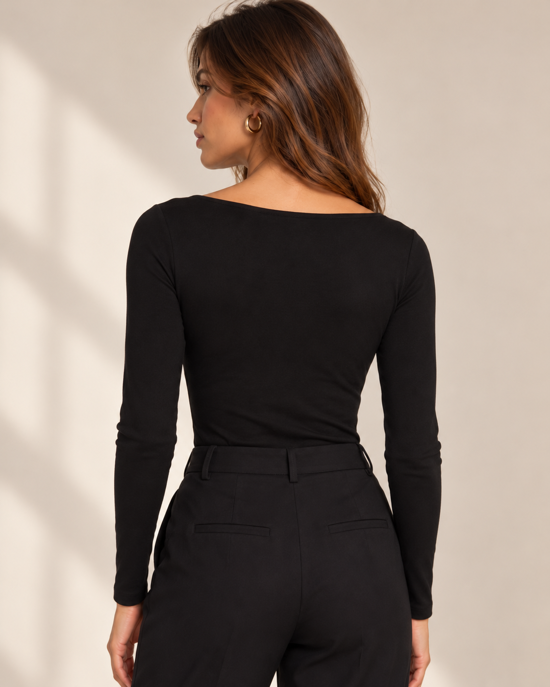 Camiseta Morgan TLADIES negra de manga larga – vista trasera Vista trasera de camiseta Morgan TLADIES negra de manga larga y corte entallado, combinada con pantalón negro de cintura alta.